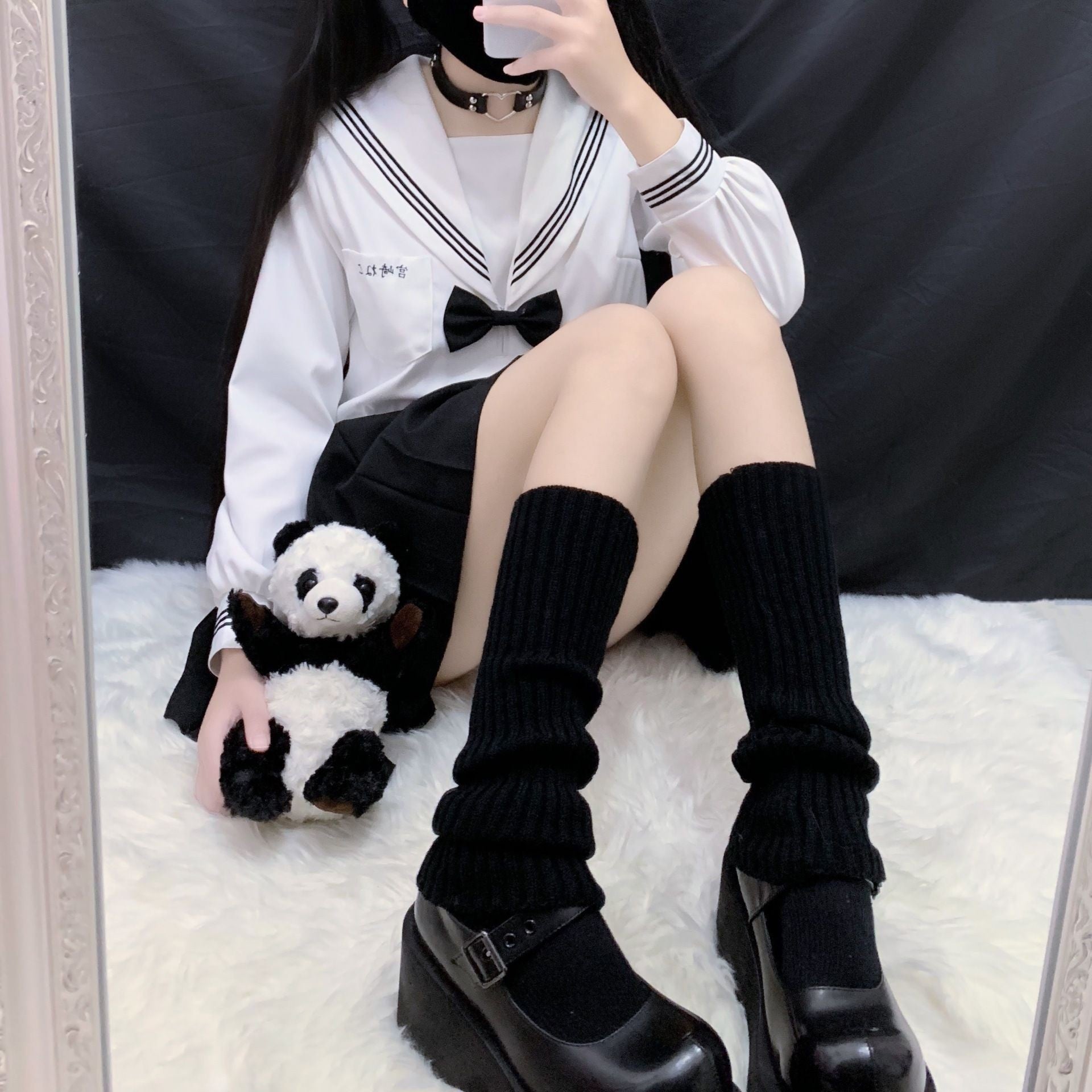 Black knitted leg warmers paired with platform heels and pleated skirt, soft femboy fashion streetwear look