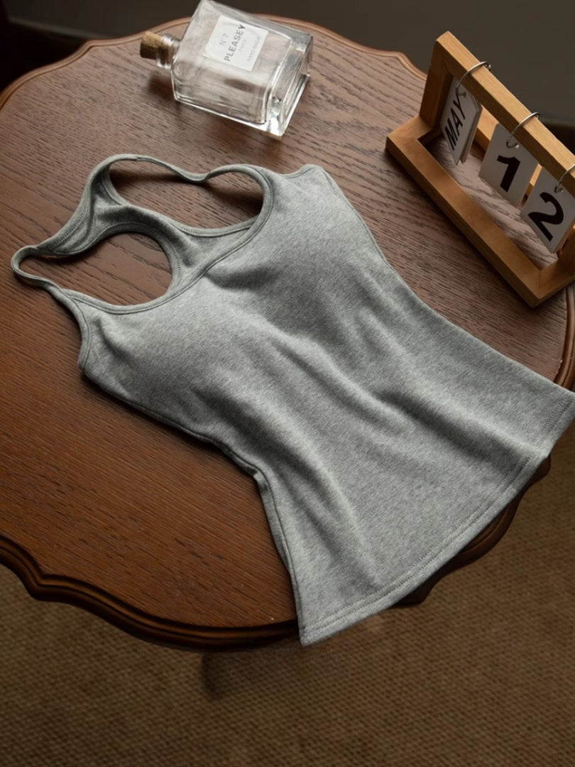flat-lay styled shot, top-down — grey racerback tank on wooden table with perfume, casual femboy tank top