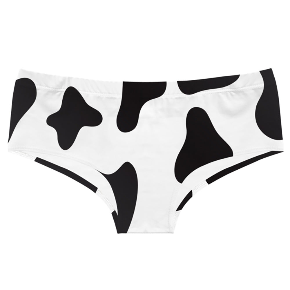 Close-up cow print femboy panties product shot, black and white pattern underwear detail