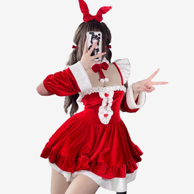 Medium shot of the Christmas Femboy Kit, featuring a layered red velvet dress with fur trim and holiday accessories, creating a playful, festive atmosphere for femboy fashion. Background shows Christmas decor, enhancing the holiday vibe.