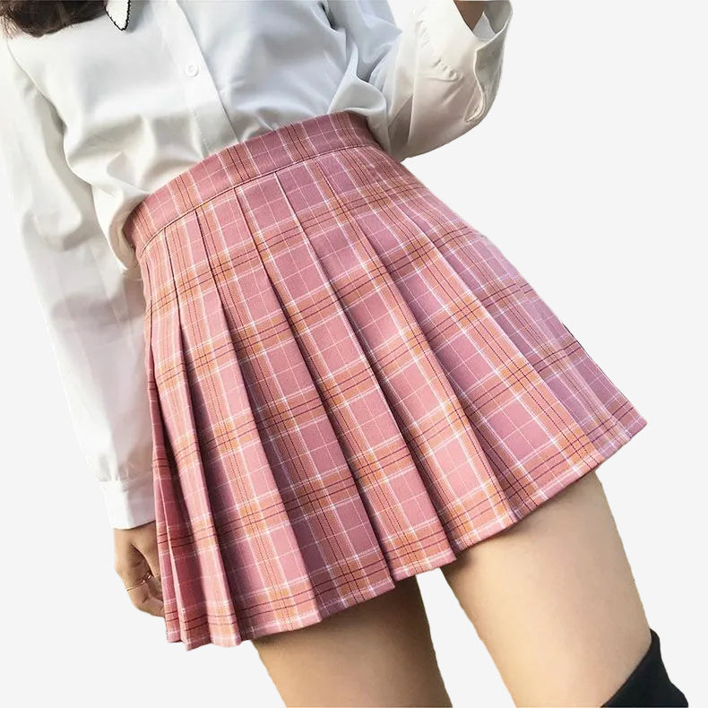 Chic pink plaid pleated skirt showcased on a young model standing by a fence, perfectly blending with femboy fashion for a youthful and fresh look.