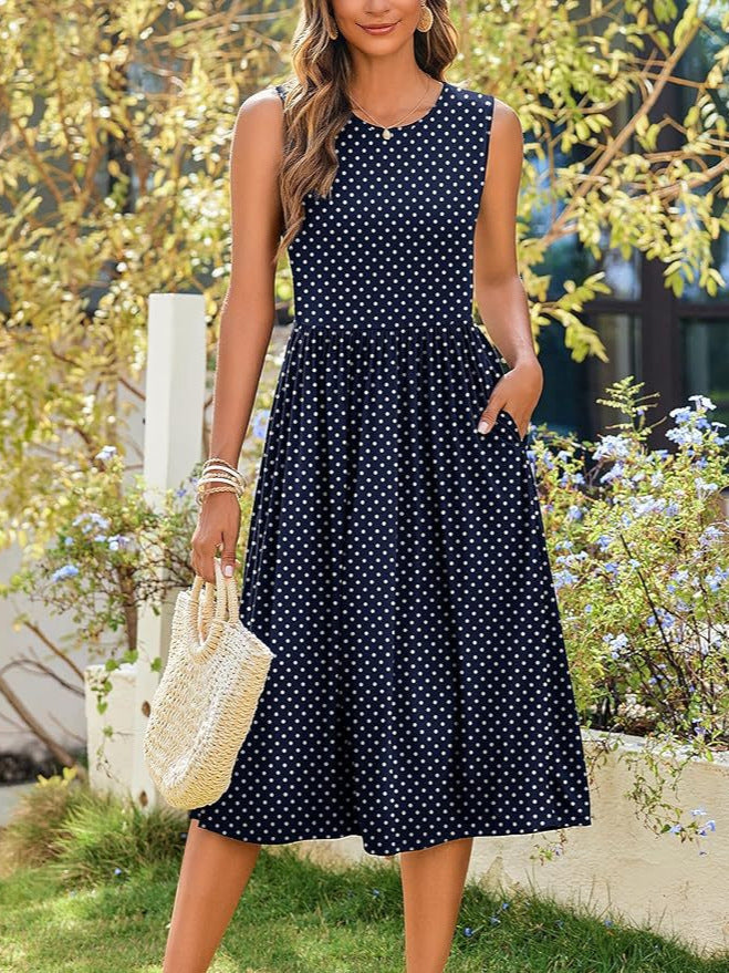 Full‑body front shot of navy polka‑dot Femboy Floral Tank Dress by garden wall, femboy dresses.