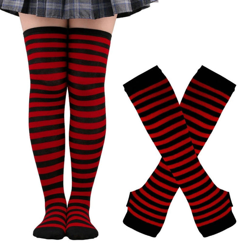 Red and black striped thigh high socks with matching arm warmers styled on model legs, bold gothic-inspired femboy clothing for alternative femboy fashion looks