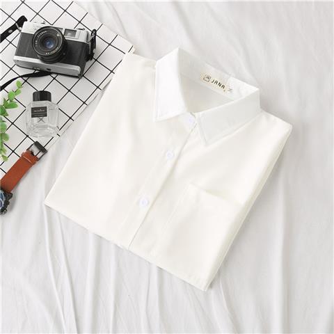 Flat lay of a white short-sleeve femboy blouse with button front and chest pocket, neatly folded on a white fabric background, minimal aesthetic femboy clothing staple.