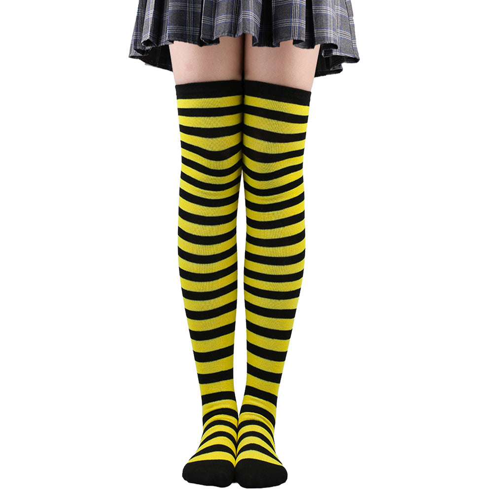 Yellow and black striped femboy thigh high socks displayed on legs, straight-on front view highlighting bold horizontal stripes and snug over-the-knee fit, clean white background, femboy clothing and femboy outfits.
