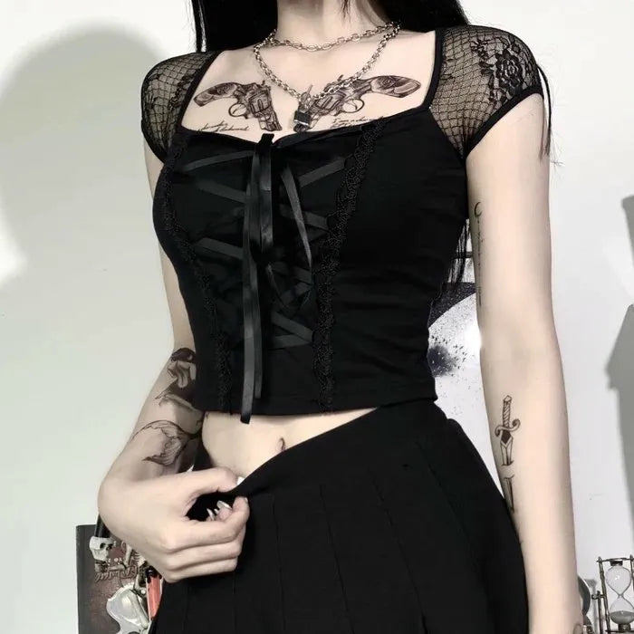 Goth femboy outfit with black lace crop top and layered ruffle skirt, dark aesthetic lifestyle shot