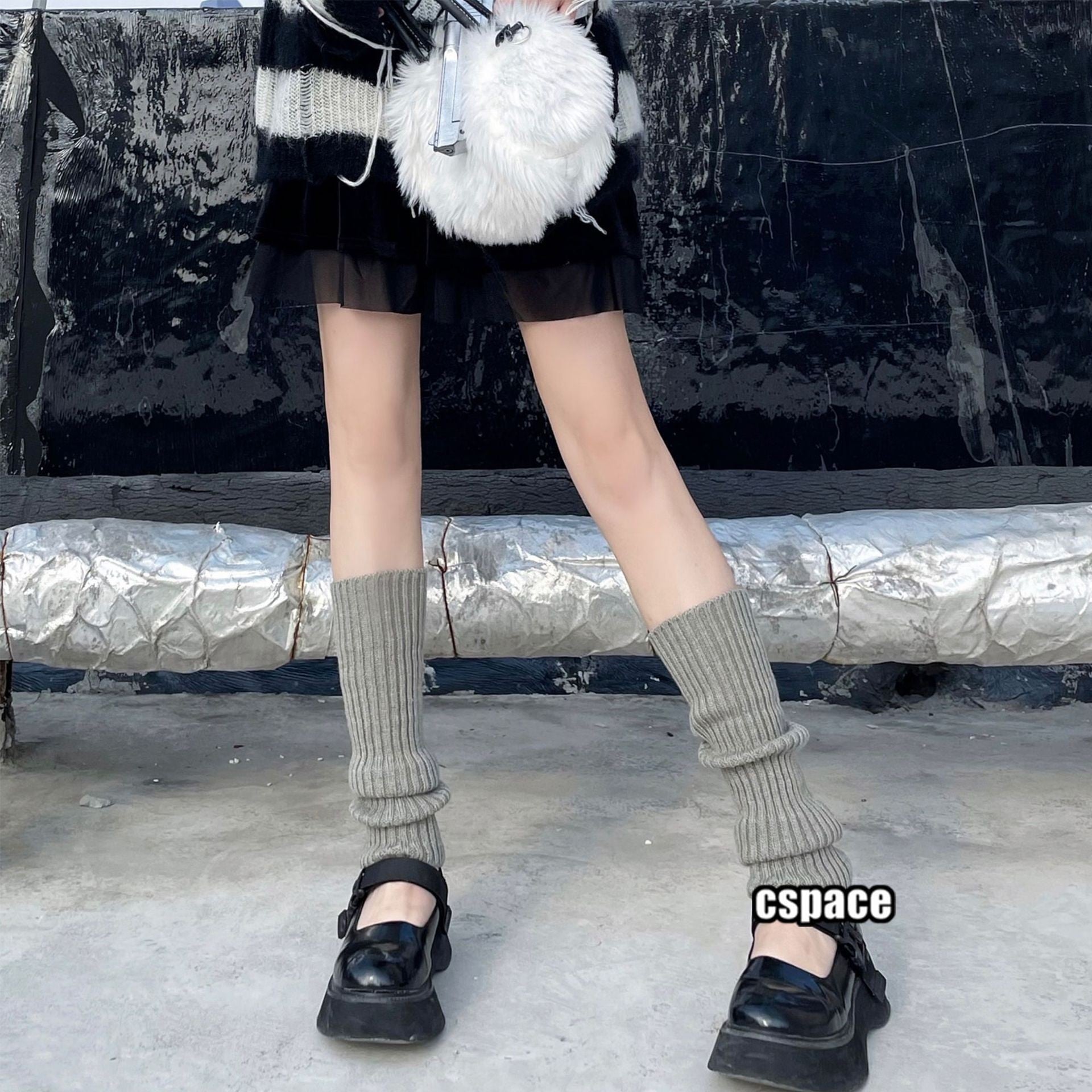 Gray knitted leg warmers styled with black platform shoes and pleated skirt, cozy layered femboy outfit aesthetic