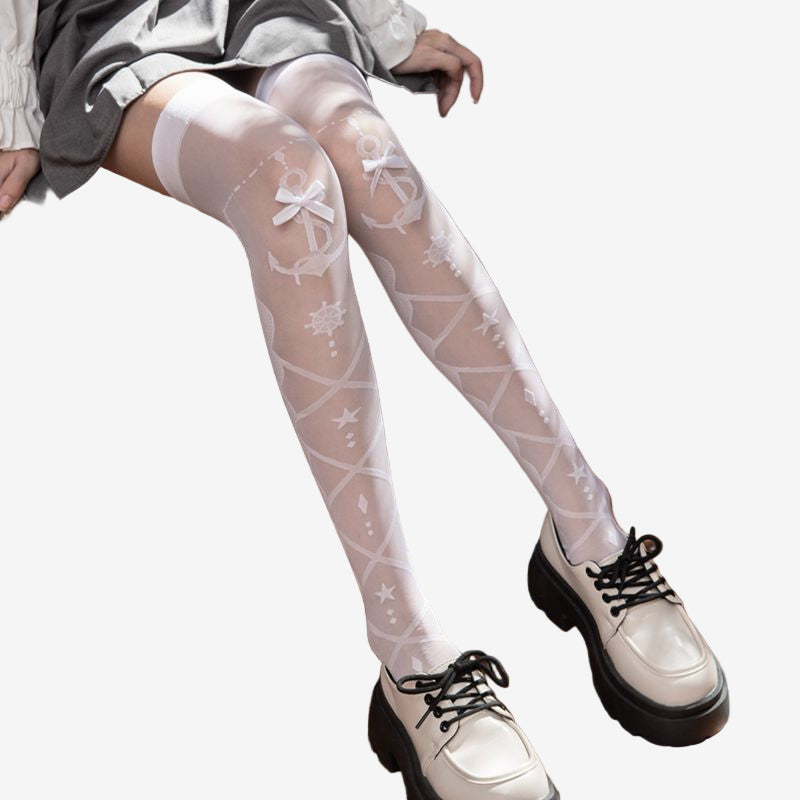 Seated view of white Lolita Femboy Thigh Highs with anchor and bow details, paired with chunky shoes on a vintage chair, perfect for showcasing femboy clothes and femboy style.