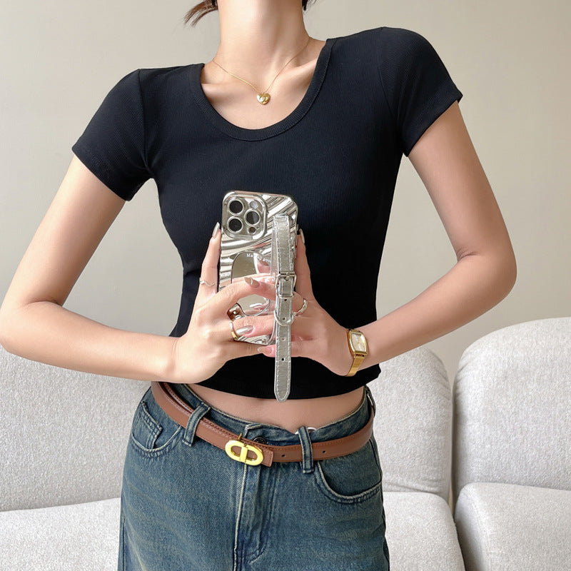 A chic black slim fit cotton tee worn by a model holding a smartphone, paired with high-waisted jeans for a trendy femboy outfit in modern femboy fashion.