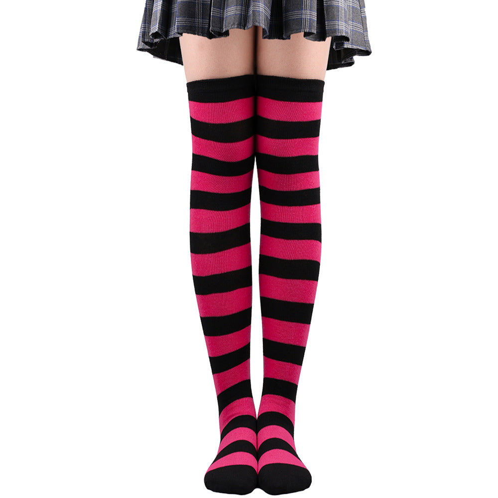 Hot pink and black striped femboy thigh high socks shown worn in a straight-on front view, bold contrast femboy fashion accessory photographed on a white background.