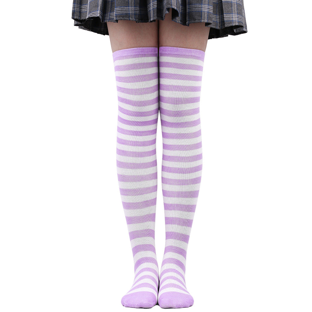 Lavender and white striped femboy thigh high socks displayed on legs in a straight-on studio photo, smooth cotton material with soft stretch, pastel aesthetic for cozy femboy outfits, photographed against a white background for femboy fashion.