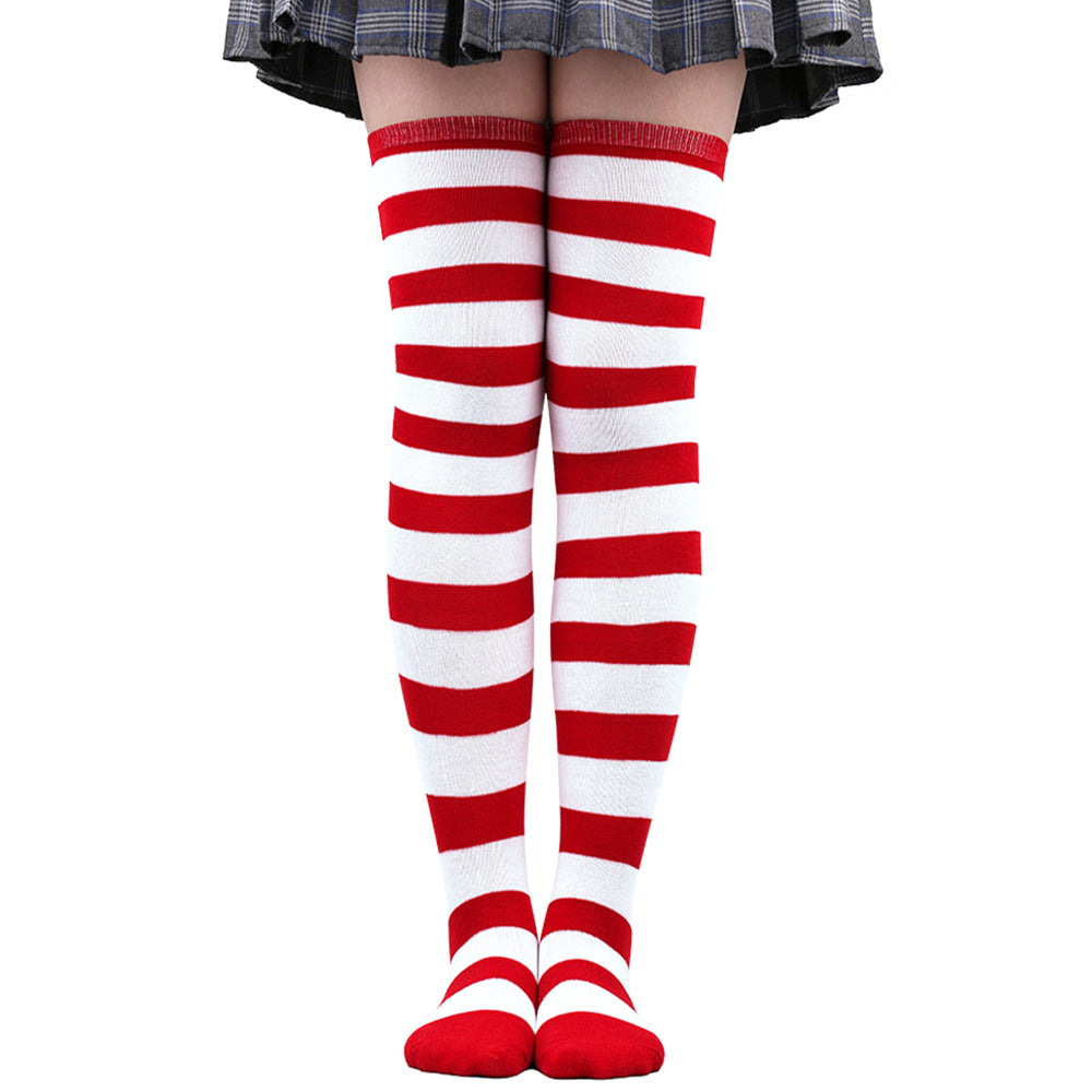 Red and white striped femboy thigh high socks worn on legs in a front-facing studio shot, soft cotton stretch fabric, playful colorway for cute femboy outfits, photographed on a clean white background as part of femboy clothing fashion.
