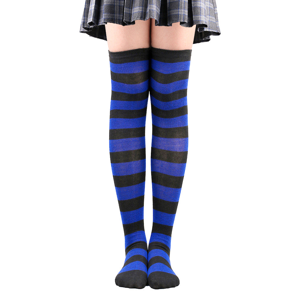 Royal blue and black striped femboy thigh high socks displayed worn on legs in a centered front-facing product photo, alternative femboy clothing piece on white background.