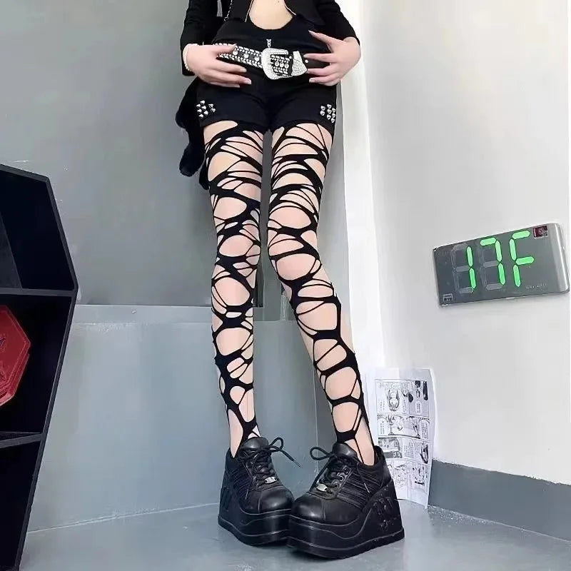 Gothic Punk Ripped Fishnet tights with large shredded patterns, paired with studded shorts and chunky platform sneakers for a bold, edgy femboy style.