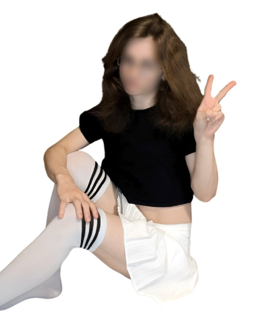 Basic Femboy Starter Kit featuring a white pleated skirt and black crop top, paired with striped thigh-high socks. The image showcases a sitting pose with a clean white background, highlighting stylish femboy clothing.