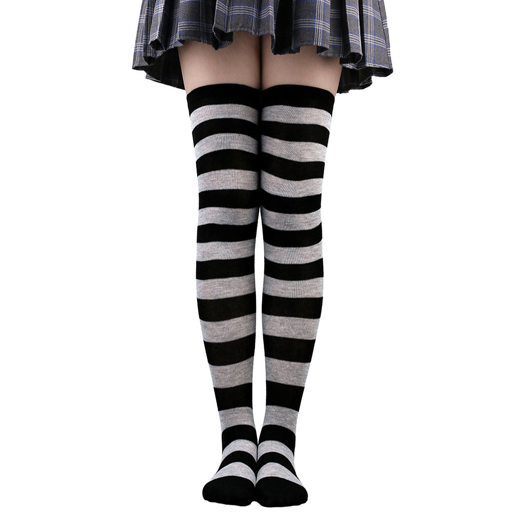 Black and grey striped femboy thigh high socks worn above the knee, symmetrical front view highlighting bold stripe contrast, classic femboy fashion styling.