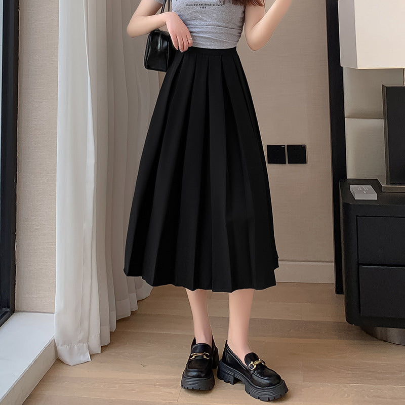 Full-body view of a black high-waisted pleated midi skirt, styled with a grey top and loafers, showing femboy fashion in classic pleats, femboy clothing