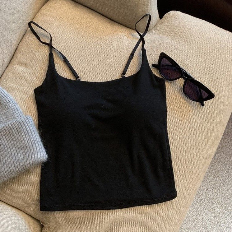 A black camisole laid flat on a beige couch, accompanied by sunglasses and a cozy gray beanie. Ideal for stylish femboy outfits and everyday femboy fashion.