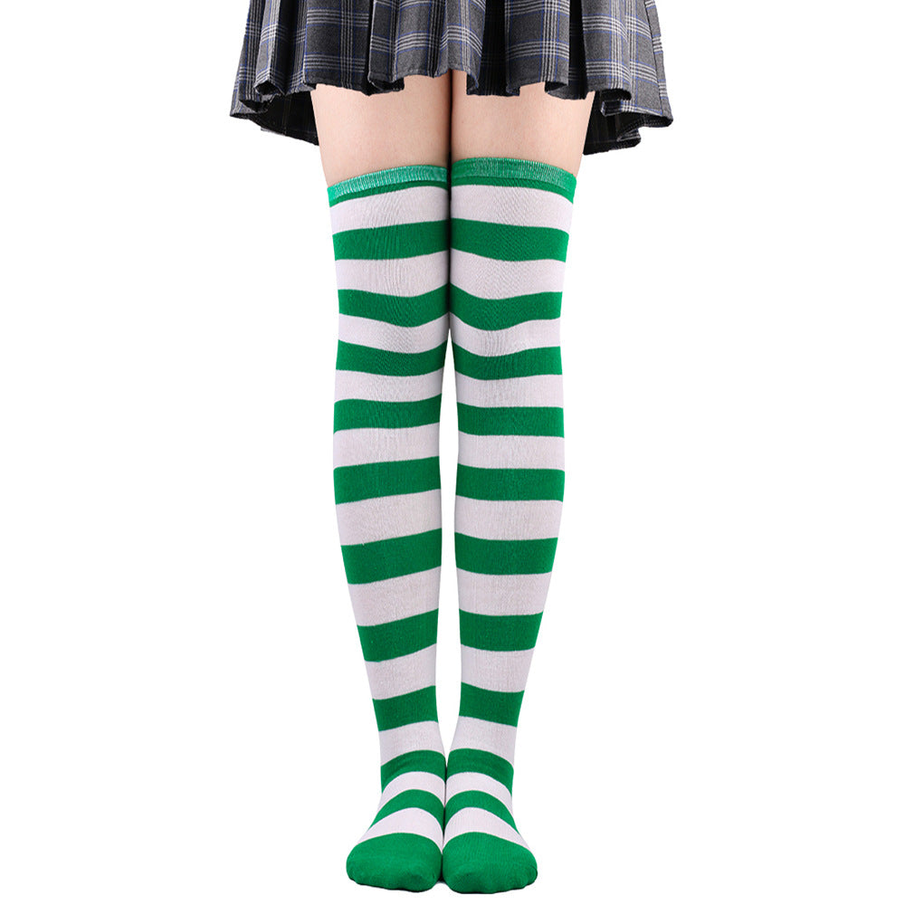 Bold green and white striped femboy thigh highs displayed on legs, full-length front view against white background, playful femboy clothing look.