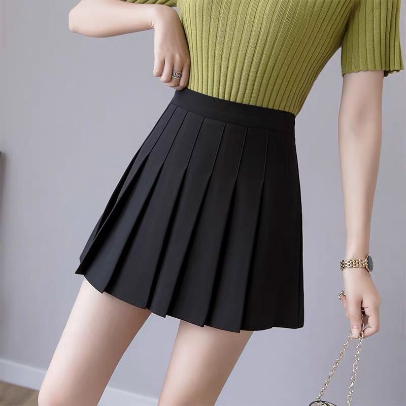 A close-up shot of a black pleated skirt, highlighting the clean pleats and high-waisted design. The gray background complements the sleek look, making this femboy clothing piece a wardrobe essential.