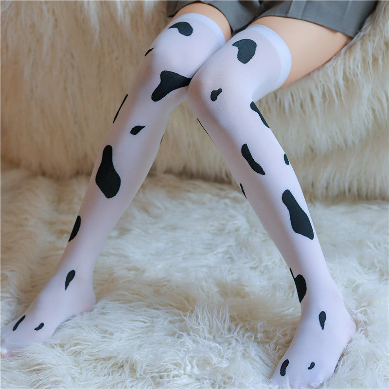 Cow print thigh high stockings flatlay, black and white pattern over the knee hosiery