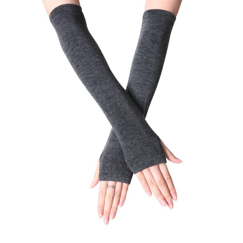 Close-up of hands in dark grey fingerless arm warmers, long and comfortable for added warmth. Perfect for femboy fashion and adding a unique touch to femboy clothes.