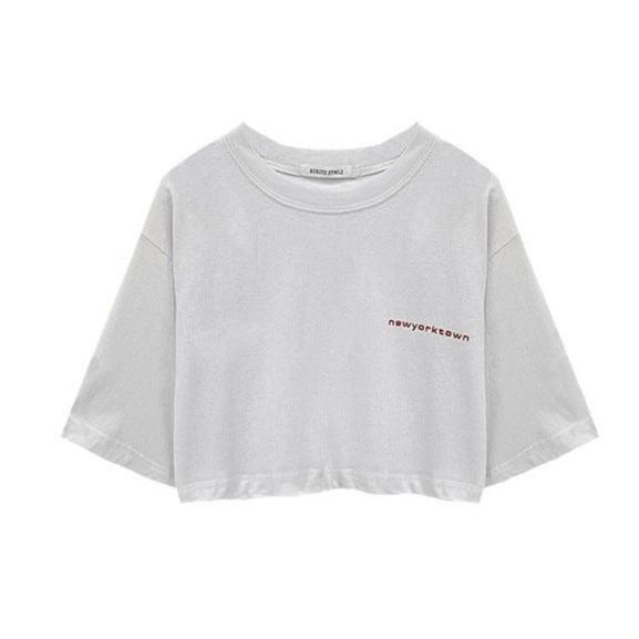 Flat-lay of a loose white crop top with subtle "newyorktown" text, showcasing minimalist femboy style clothing.