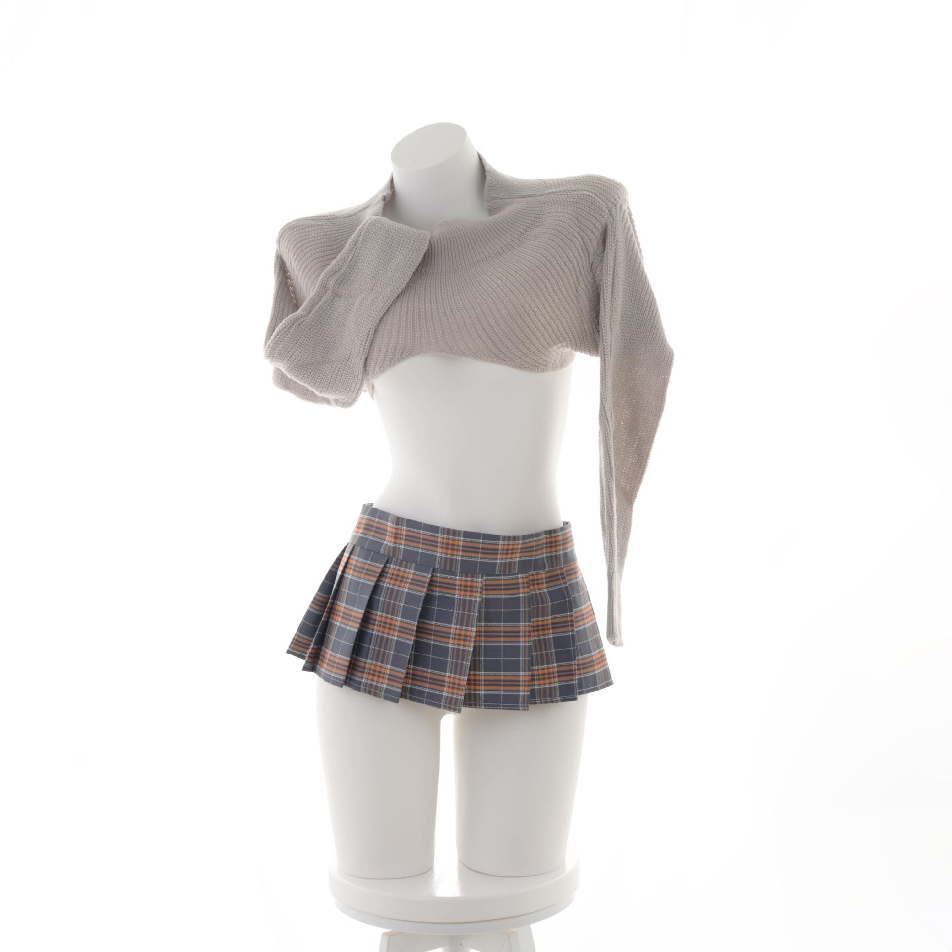 Mannequin display of the Plaid Lowcut Femboy Skirt in blue and orange plaid, paired with a beige cropped sweater. The skirt’s pleated design and low waist are highlighted in this studio shot, making it an essential piece for showcasing femboy clothing and stylish femboy outfits.