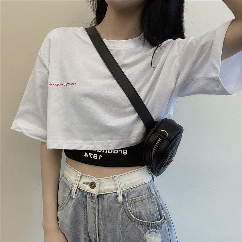 A styled look with a loose white crop top and light-wash jeans, perfect for femboy fashion enthusiasts.