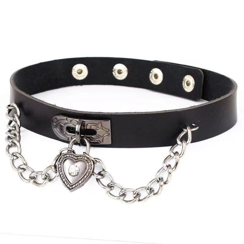 Black leather gothic femboy choker featuring a decorative heart lock charm and silver chain accents, close-up product shot on white background for femboy fashion styling.