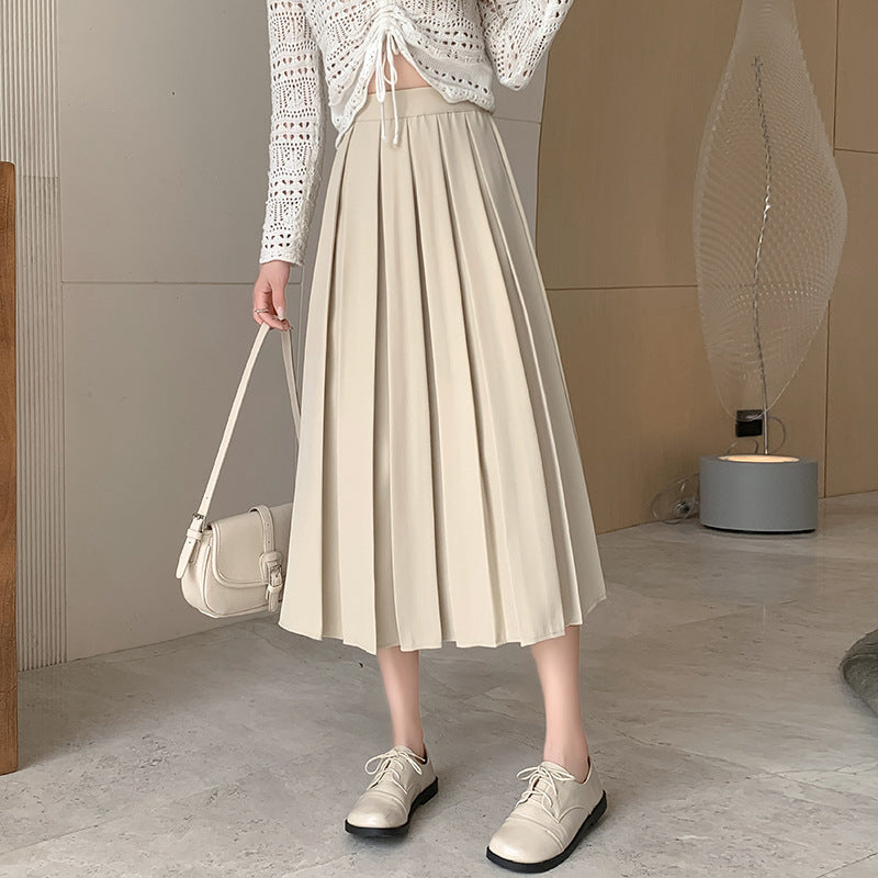 Mid-shot of model in a cream high-waisted pleated skirt with a boho-inspired crochet top, standing in a bright, natural-lit indoor environment. Perfect for femboy outfits emphasizing a light, airy style.