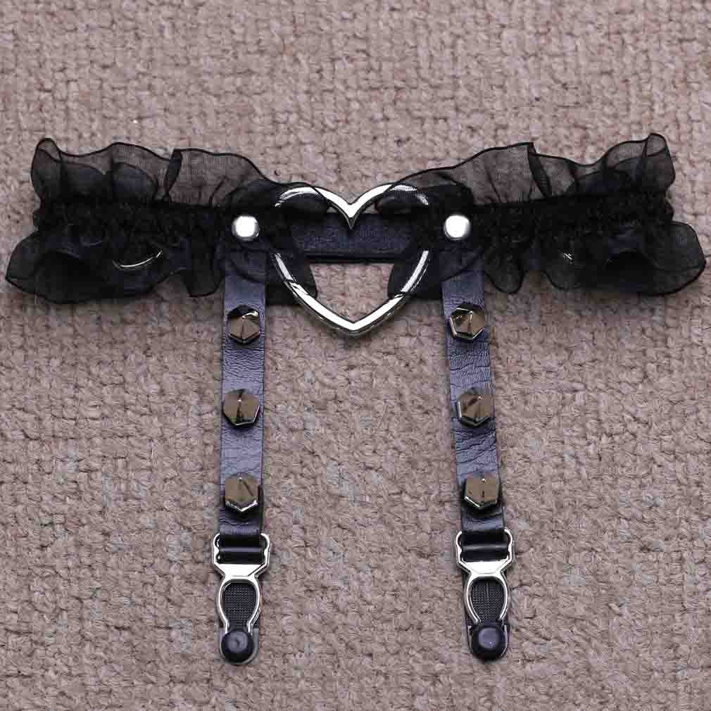 Top-down product shot of the black Heart Lace Femboy Garter taken from an overhead angle, featuring black sheer lace trim, dark adjustable straps, metallic studs, and a silver heart connector, a bold and sexy femboy accessory suited for gothic and sexy femboy outfit aesthetics.
