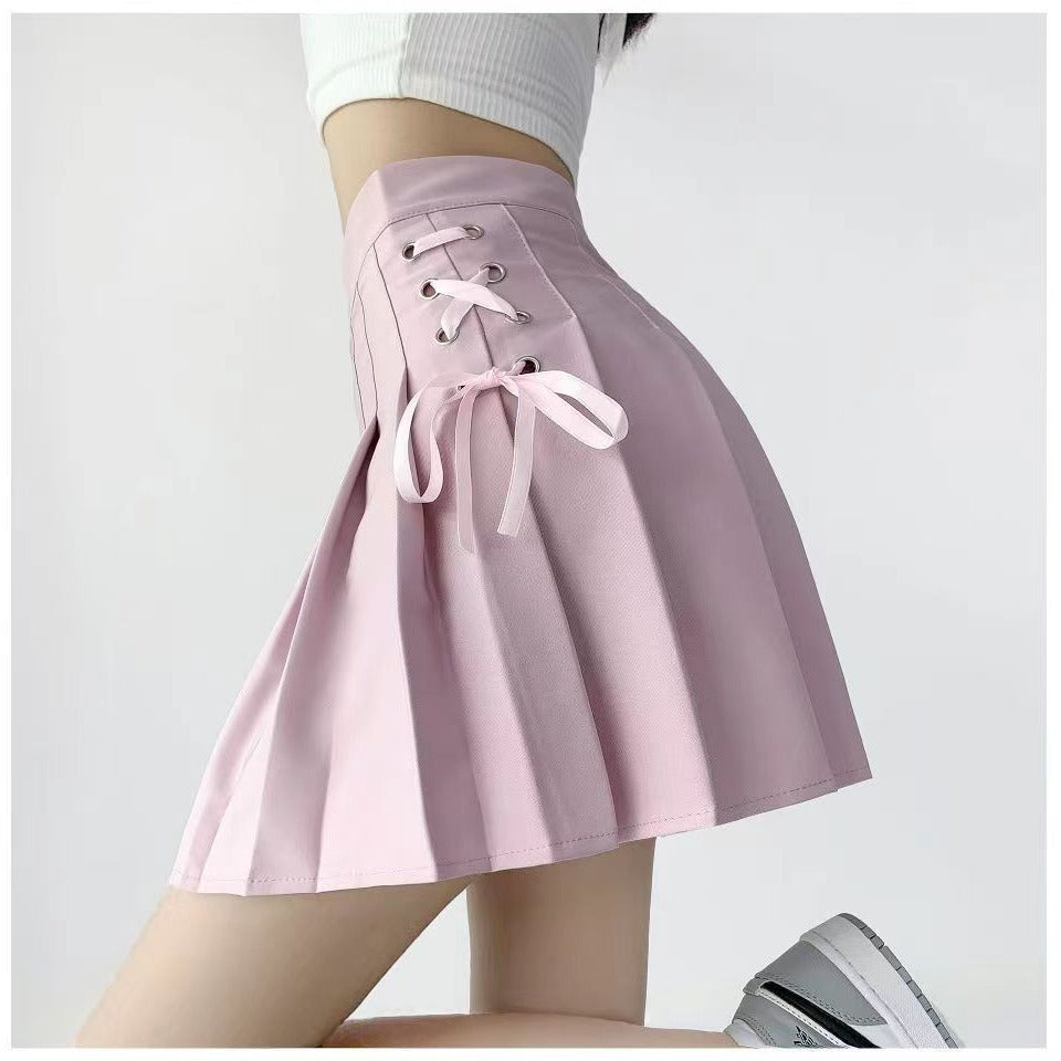 Pink Bowknot Lace Plaid Skirt on a model, featuring side lace-up detailing and a clean pleated structure. The soft pink color adds a delicate, feminine touch, perfect for modern femboy fashion.