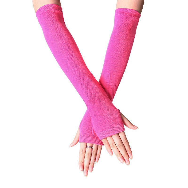 Close-up of hands in pink fingerless knit arm warmers, long and cozy, adding a cute touch to femboy fashion. Great for keeping warm with femboy clothes in colder seasons.