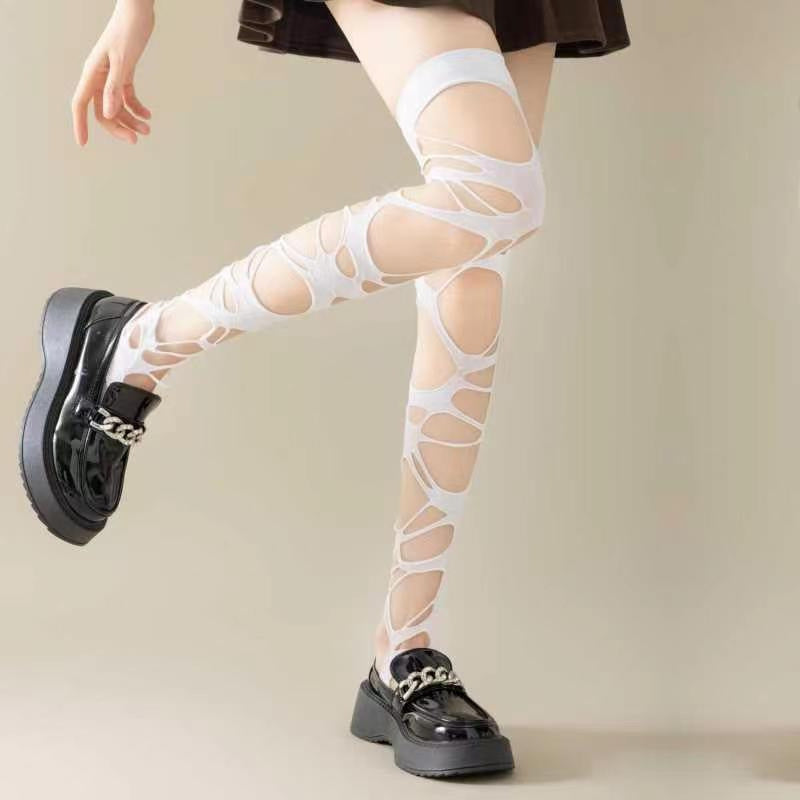 White ripped fishnet tights in gothic punk style, unique abstract cutouts, modern femboy fashion paired with oversized top and platform footwear