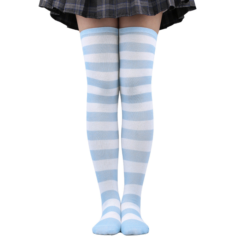 Light blue and white striped femboy thigh high socks worn above the knee, front-facing close-up on model wearing a pleated skirt, soft aesthetic femboy clothing style.