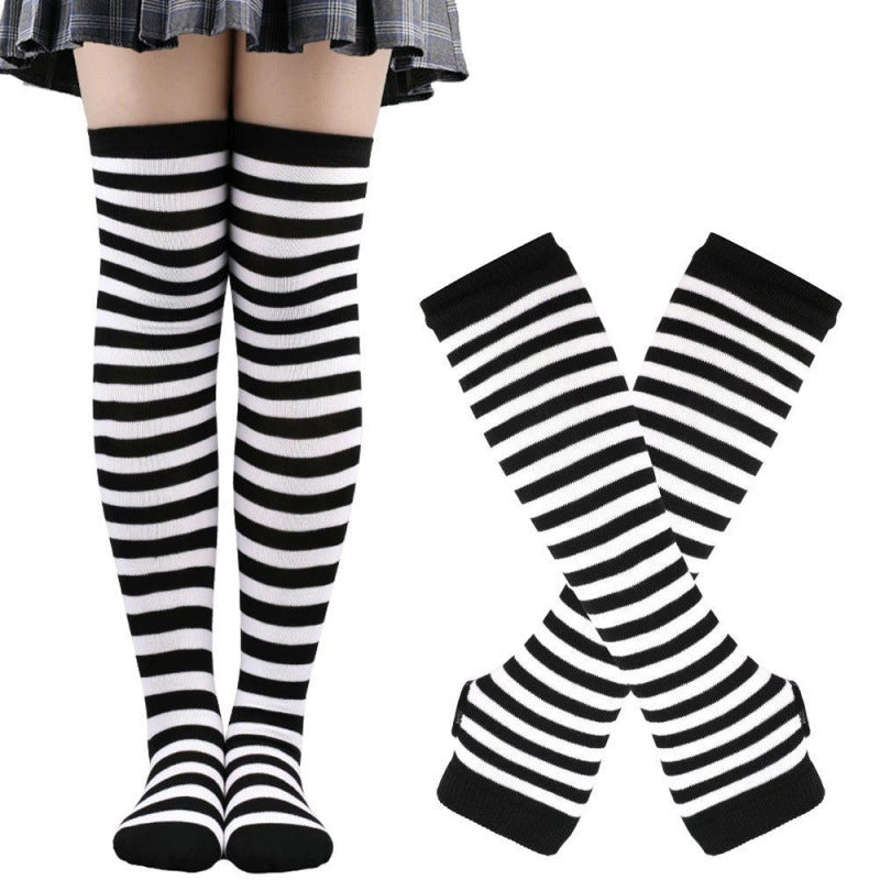 Black and white striped thigh high socks worn on model indoors, front-facing leg shot with matching striped handwarmers shown crossed beside, cotton knit texture, white background, femboy clothing set.