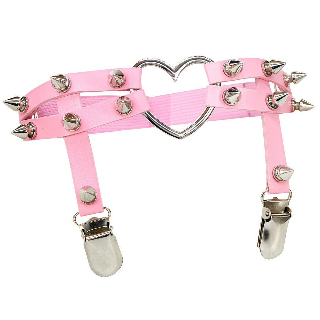 Front-facing studio shot of the baby pink Studded Heart Femboy Thigh Garter photographed on a white backdrop, emphasizing soft pink faux leather, silver spike accents, adjustable thigh straps, and a glossy heart ring, a cute femboy accessory for pastel outfit aesthetics.
