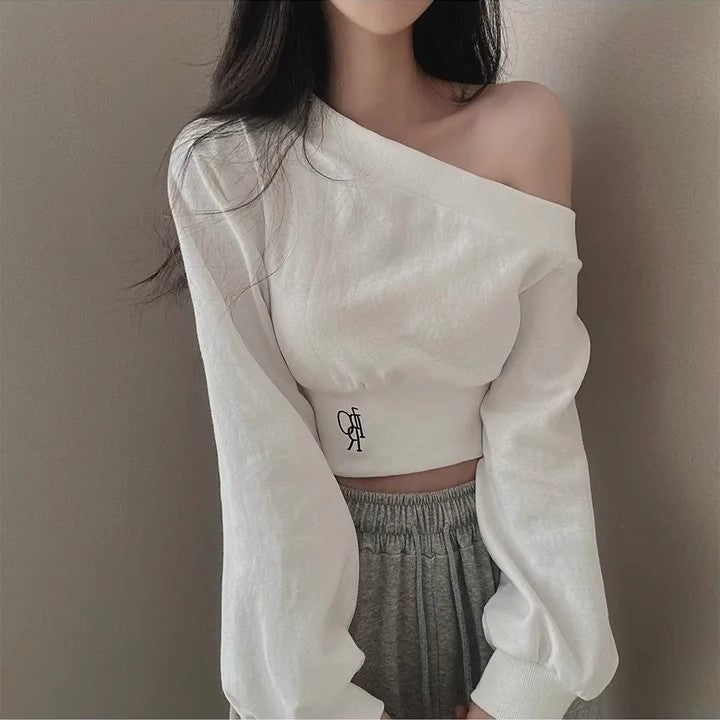 Front view shot of model wearing white one-shoulder femboy crop top with long balloon sleeves and elastic waist hem – minimalist femboy clothing outfit aesthetic