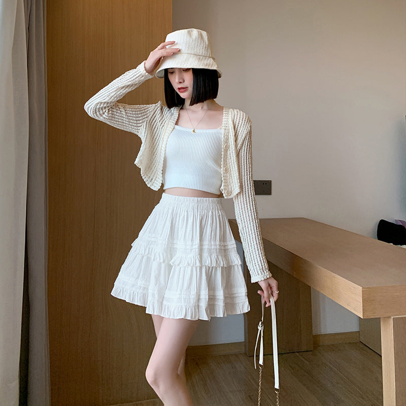 Model wearing a stylish white lace femboy skirt with a cardigan, showcasing a soft and elegant look for femboy fashion lovers.