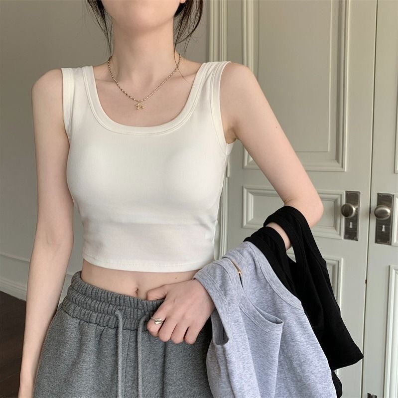 White tank top styled with gray sweatpants, offering a relaxed yet fashionable option in femboy clothing for everyday wear.